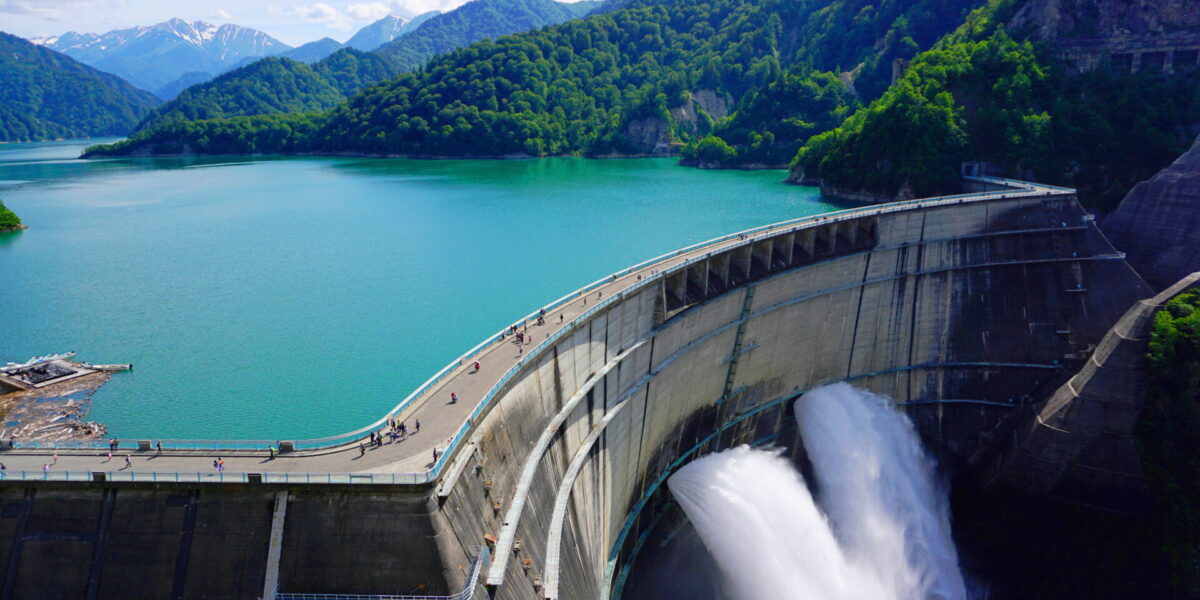 Aerial view of the imposing Kurobe Dam in Japan, surrounded by majestic mountains.
