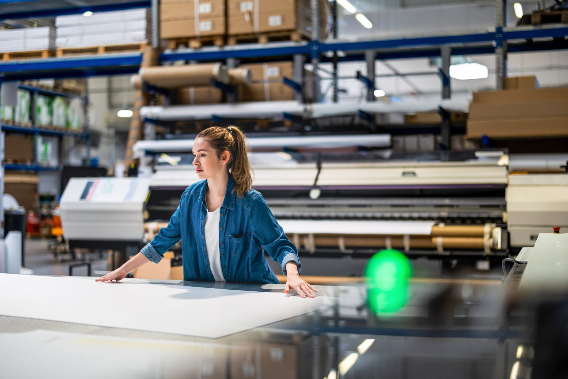 Woman standing at a large format printer