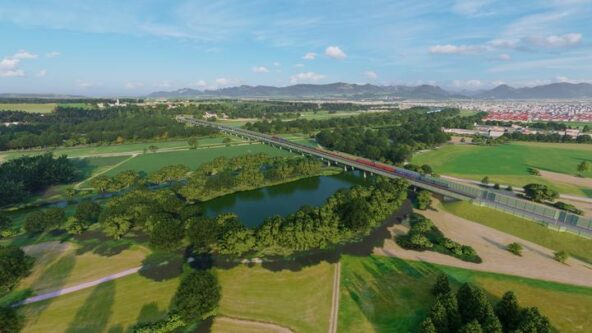 Eine Luftaufnahme eines grünen Feldes und einer Brücke.