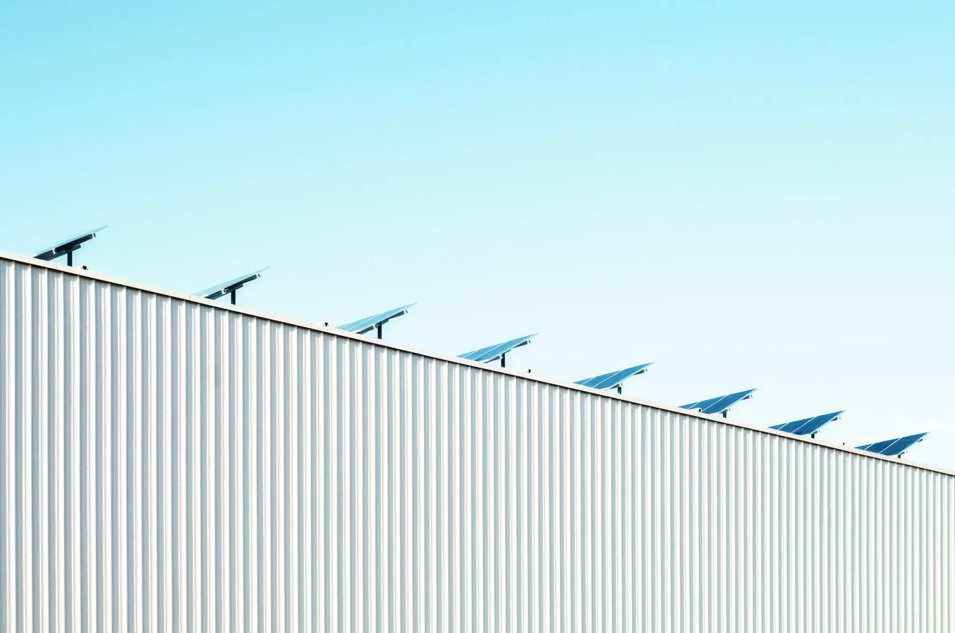 Solarmodule auf einem flachen Dach unter klarem, blauem Himmel – nachhaltige Energiegewinnung durch Sonnenkraft.