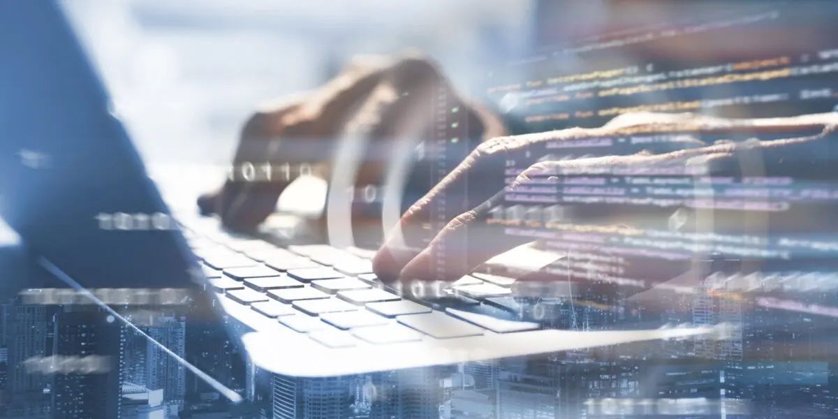 Image montage with illuminated city below, close-up of hands typing on a keyboard and code on the screen - symbolising programming and technology.