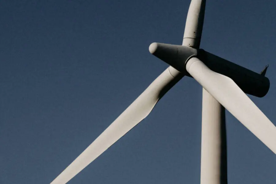 Eine Windturbine vor einem klaren blauen Himmel, symbolisiert saubere Energie.