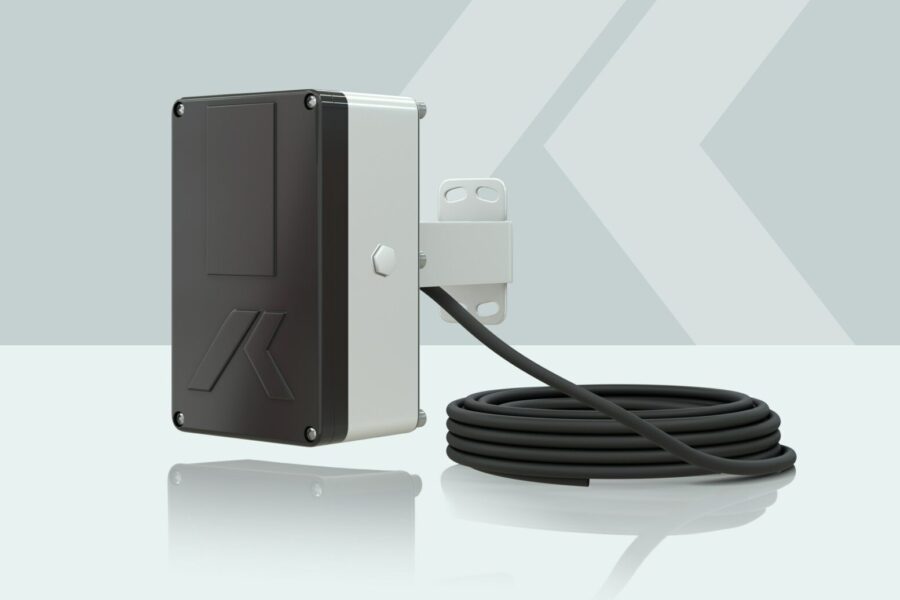 A rectangular electronic device with a black front panel, mounted on a bracket, and a long coiled cable attached. The background has a light gray geometric pattern.