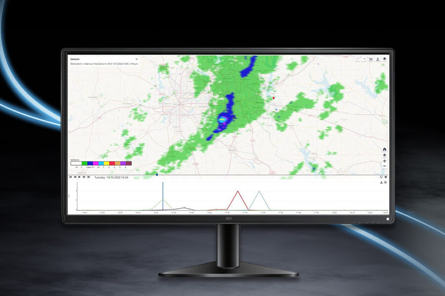 A computer monitor displays a weather radar map with green and blue precipitation patterns, overlaid on a geographic map, and a graph with colored lines beneath the map. The background is dark with blue curved light streaks.