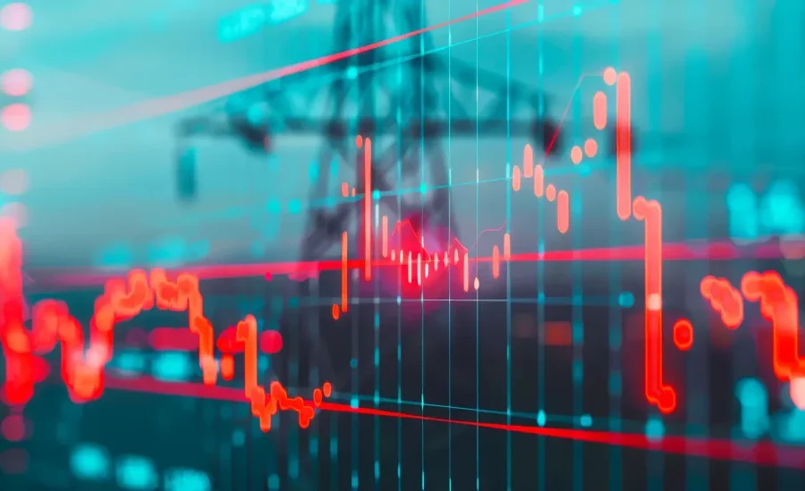 Ein digitales Diagramm mit roten und blauen Linien, die schwankende Daten anzeigen, wird über einen unscharfen Hintergrund aus Stromleitungen und Strommasten gelegt.